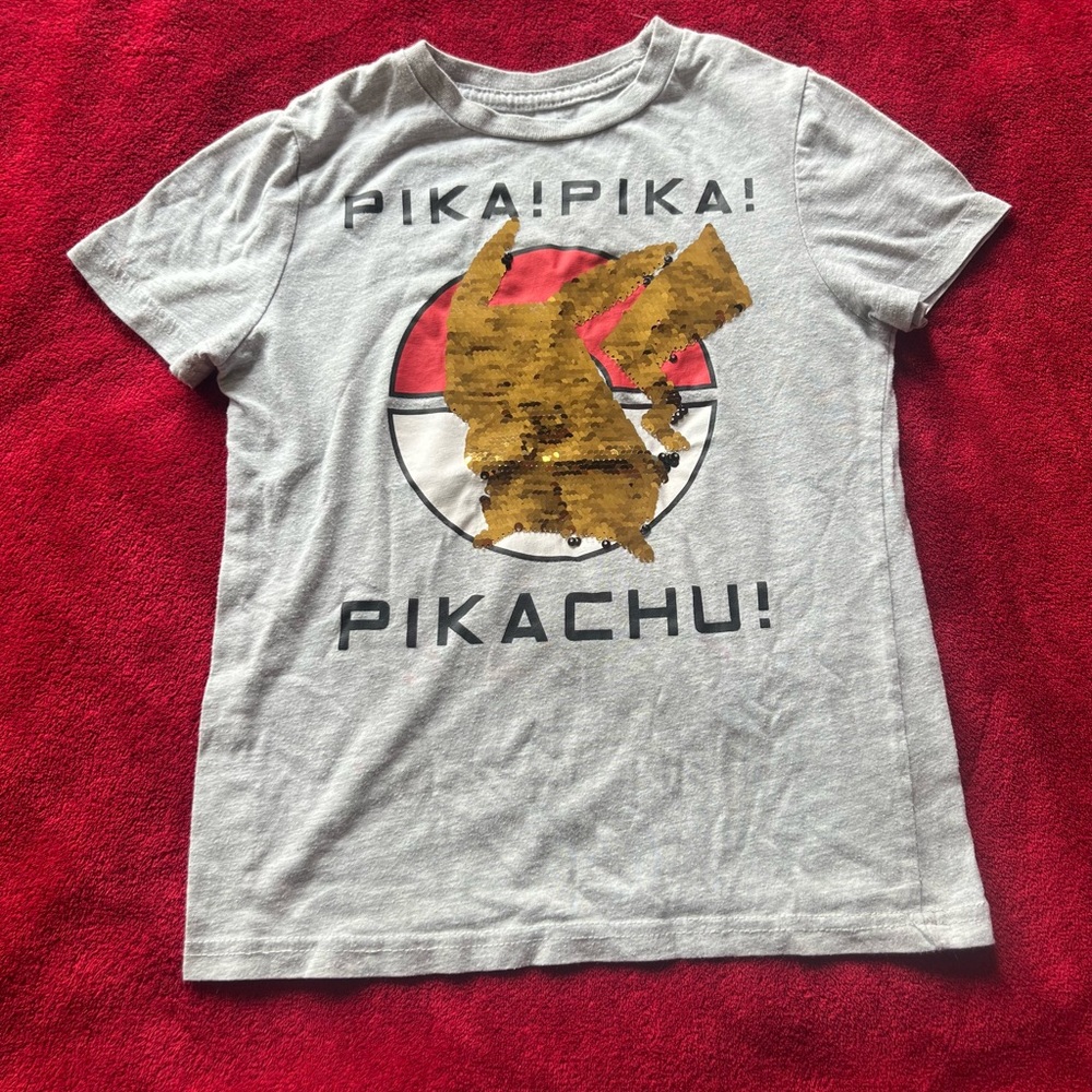 shirt for boy size S with change of design to gold or black, Pokémon brand.